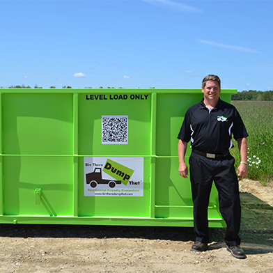A Bin There Dump That operator stands in front of a 14 yard dumpster bin