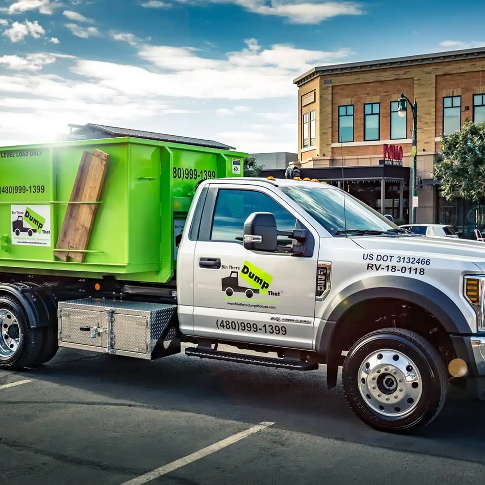 A Bin There Dump That truck and bin parked on a city street in sunset