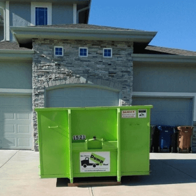 A clean Bin There Dump That dumpster sits in a residential driveway
