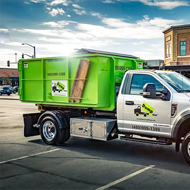 A Bin There Dump That truck and bin parked on a city street in sunset